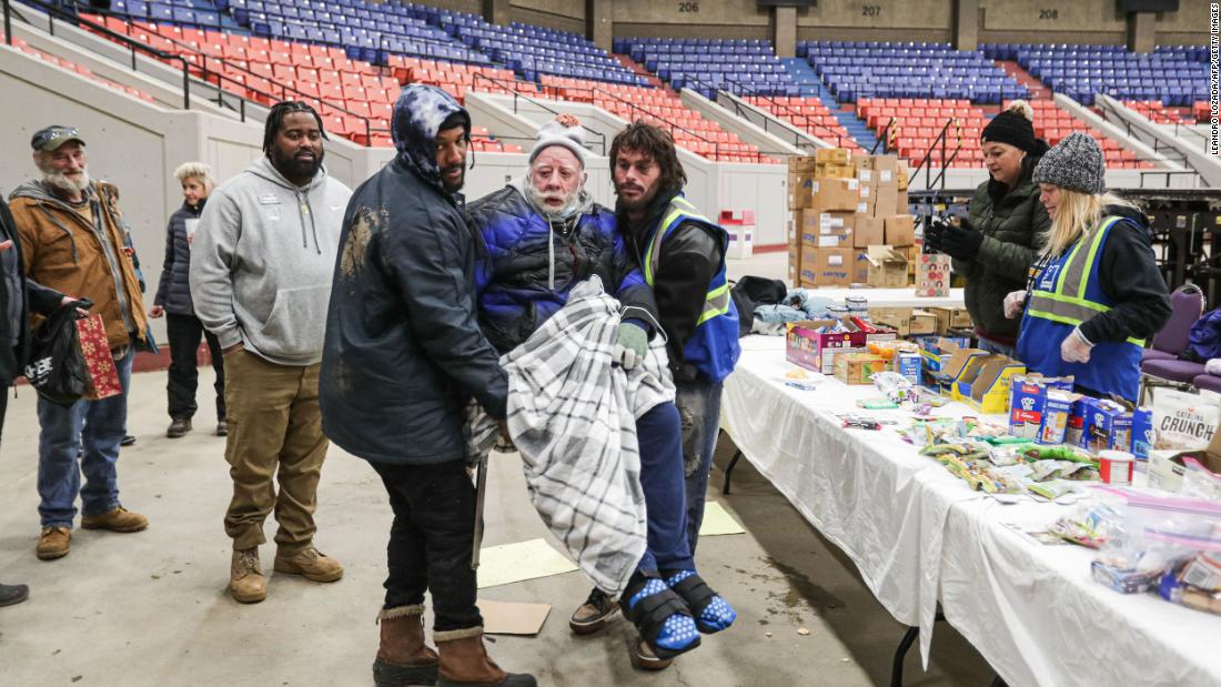 Volunteers welcome a homeless person to a shelter at Louisville&#39;s Broadbent Arena on December 23.