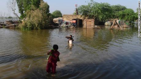 Flood-affected people carry belongings out from their flooded home in Shikarpur, Sindh province,  in Pakistan in August.