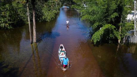 A man pulls a canoe through a flooded street of his neighborhood in New Smyrna Beach, Florida, after Hurricane Ian slammed the area in September.