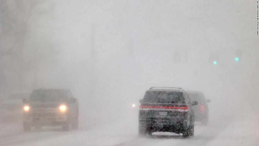 Cars drive in whiteout conditions in Orchard Park, New York, on December 23.