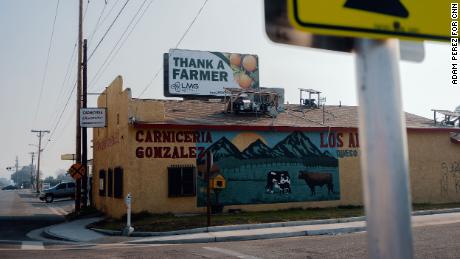 A sign reading &quot;thank a farmer&quot; sits atop a building in Ivanhoe, California.