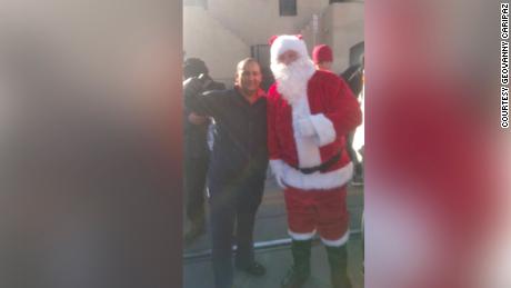 Geovanny Caripaz, 39, takes photo with Santa Claus on Christmas Day at a migrant shelter in El Paso, Texas.