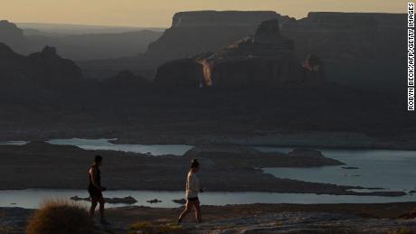 Visitors watch the sunrise over a shrinking Lake Powell from Alstrom Point in Big Water, Utah, in September.