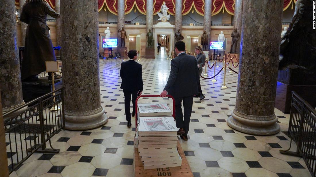 House staff wheel a large cart of pizzas through Statuary Hall late on Tuesday night. McCarthy continued to negotiate Tuesday night, sources said, in an effort to get to 218 votes.