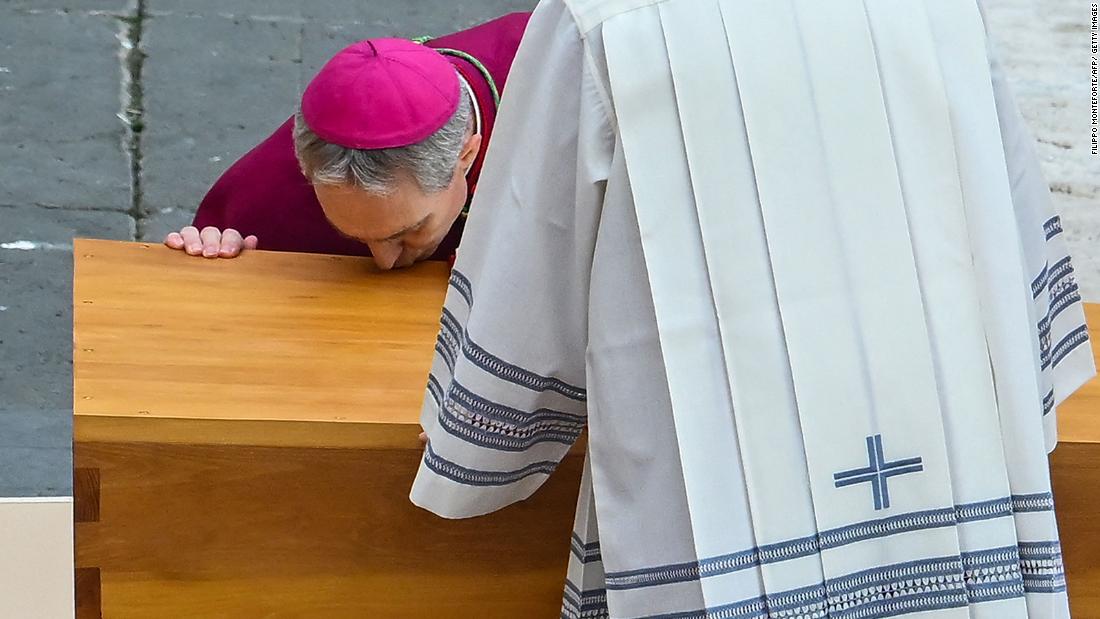 German Archbishop Georg Gaenswein kisses the coffin of Pope Emeritus Benedict XVI at the start of his funeral mass at St. Peter&#39;s Square in the Vatican.