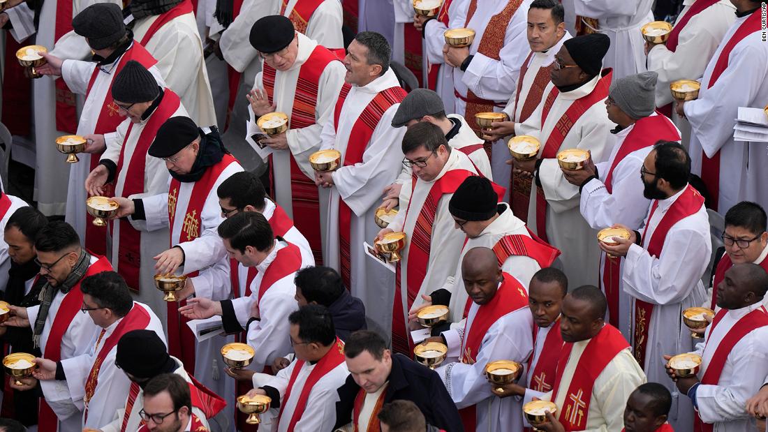 Priests prepare for the holy communion during the funeral mass.
