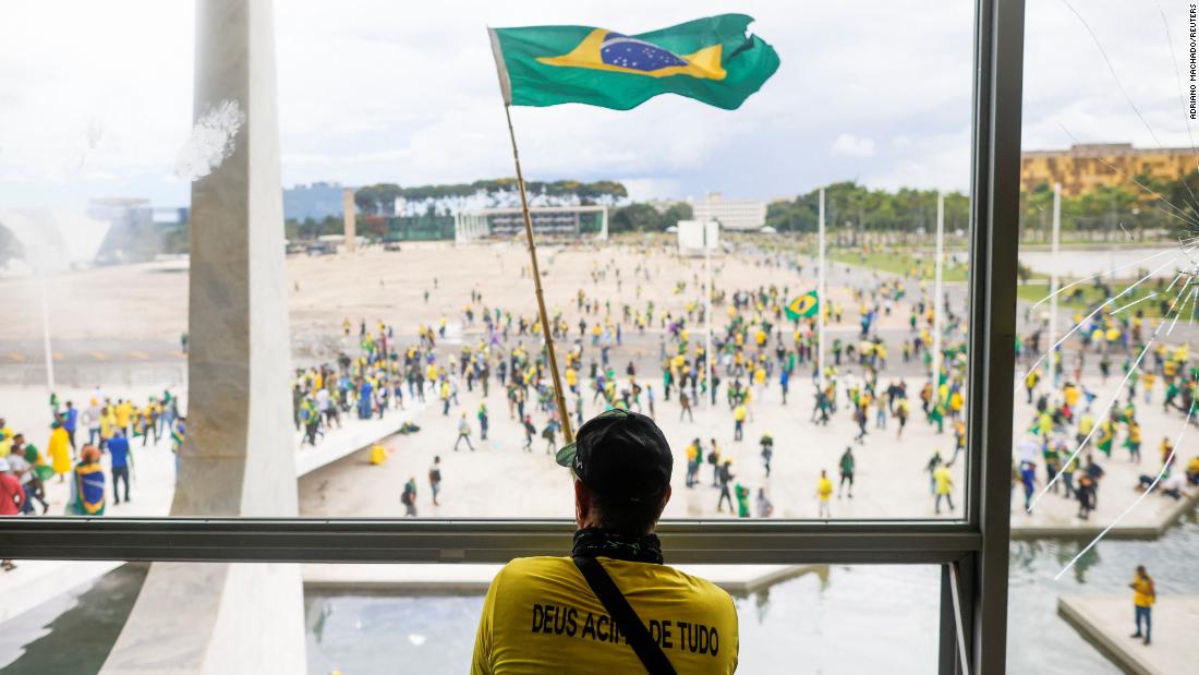 A man waves Brazil&#39;s flag from the window of the National Congress in Brasilia.