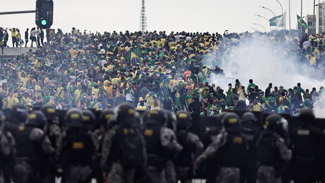 Security forces stand guard as supporters of former President Jair Bolsonaro demonstrate outside Planalto Palace in Brasilia.
