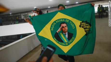 A supporter of Brazil&#39;s former President Jair Bolsonaro holds a flag depicting him during a demonstration against President Luiz Inacio Lula da Silva, in Brasilia, Brazil, January 8, 2023. REUTERS/Adriano Machado
