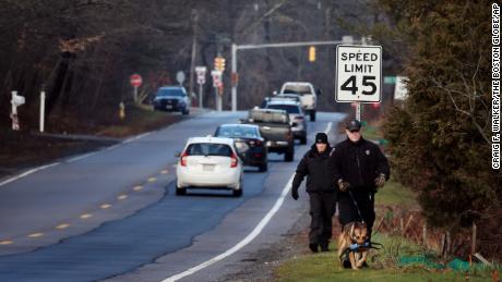 Members of a State Police K-9 unit search along a highway in Cohasset, Massachusetts, on January 7.