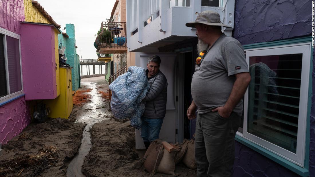 Santa Cruz residents clear storm debris and stack sandbags near their homes on January 7.