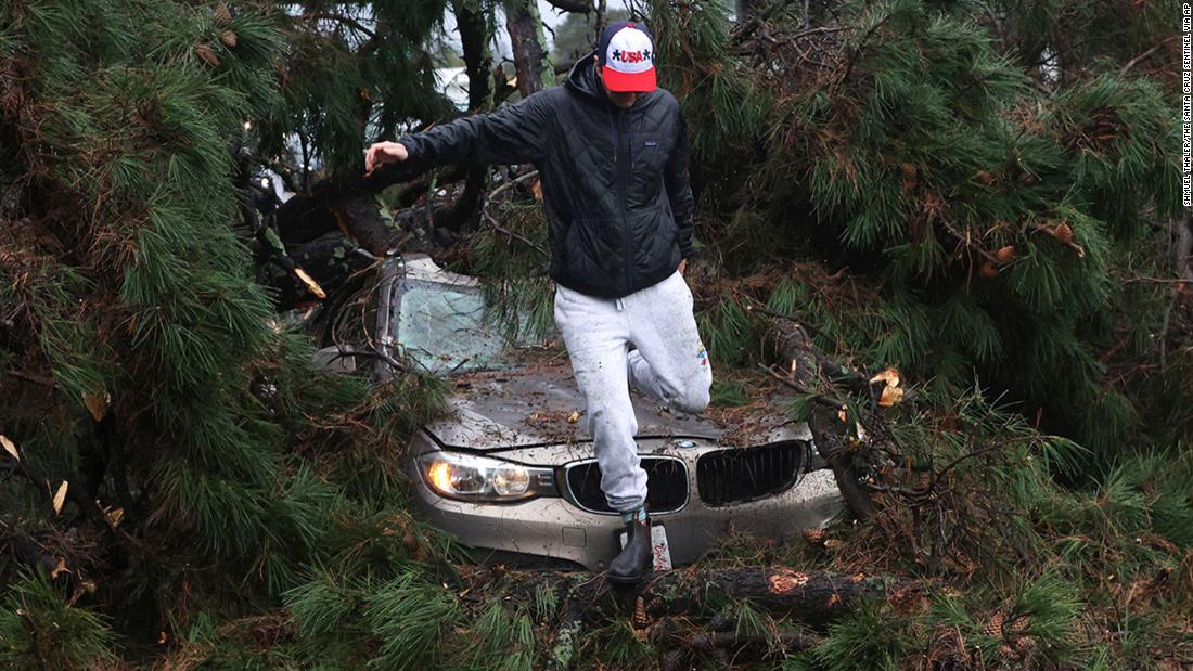 Boone White leaps from his car after a large tree fell on it while he was driving near Capitola.