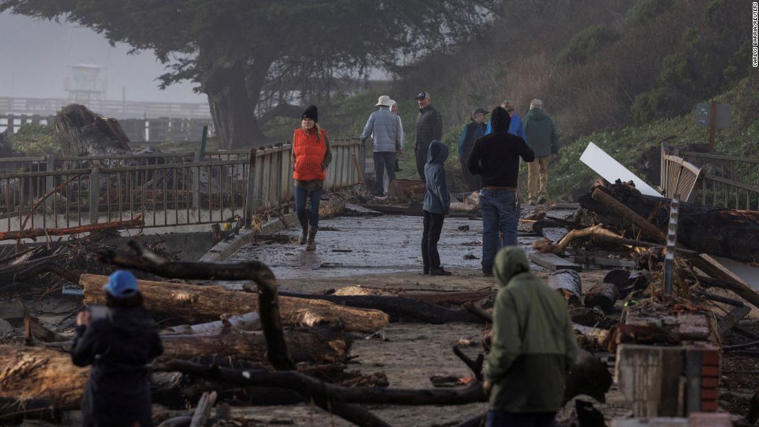Residents walk in a damaged area of Aptos on January 5.