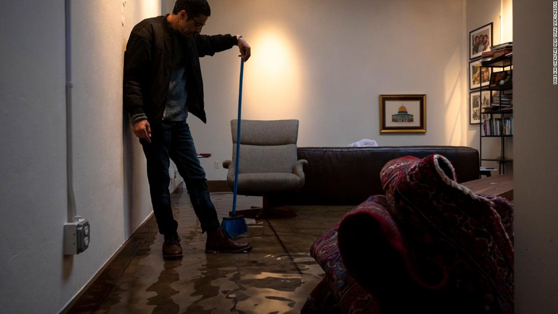 Khaled Dajani clears water from his flooded living room in San Francisco on December 31. 