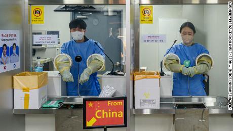 South Korean quarantine officials seen preparing PCR tests for travelers arriving from China at the Incheon International Airport near Seoul.