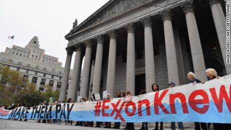 Climate activists on the first day of  ExxonMobil&#39;s trial outside the New York State Supreme Court building in October 2019. Exxon won the case, which alleged the company had misled over climate change.