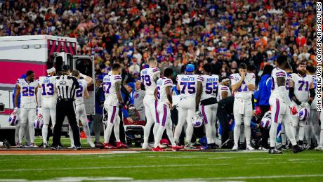 The Buffalo Bills gather as an ambulance parks on the field while CPR is administered to Bills safety Damar Hamlin.