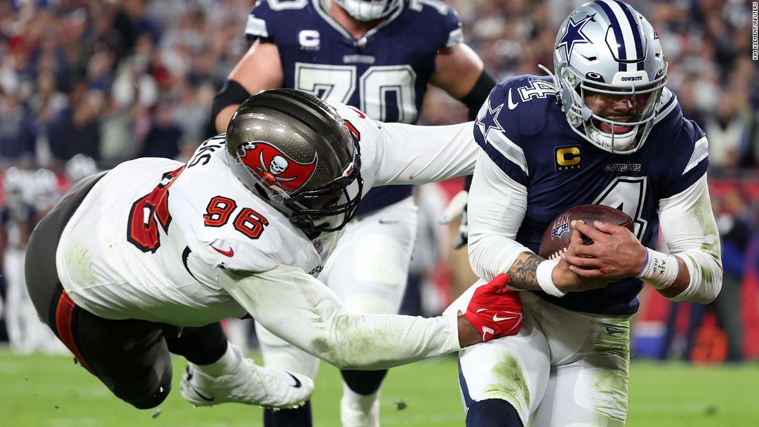 Dallas Cowboys quarterback Dak Prescott rushes the ball for a touchdown against Tampa Bay Buccaneers defensive end Akiem Hicks in the first half. Prescott accounted for five touchdowns -- one rushing and four passing -- in the Cowboys&#39; 31-14 victory over the Bucs to set up a clash against the San Francisco 49ers in the next round of the playoffs.