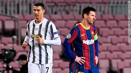 Cristiano Ronaldo (L) walks past Argentinian Lionel Messi during a UEFA Champions League football match in Barcelona on December 8, 2020. 