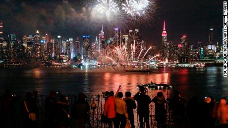 Fireworks explode in New York for the 2018 Lunar New Year as people in Weehawken, New Jersey, look on.
