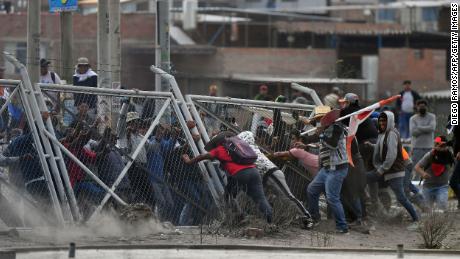 Demonstrators pull down a fence while trying to enter Arequipa&#39;s airport. 