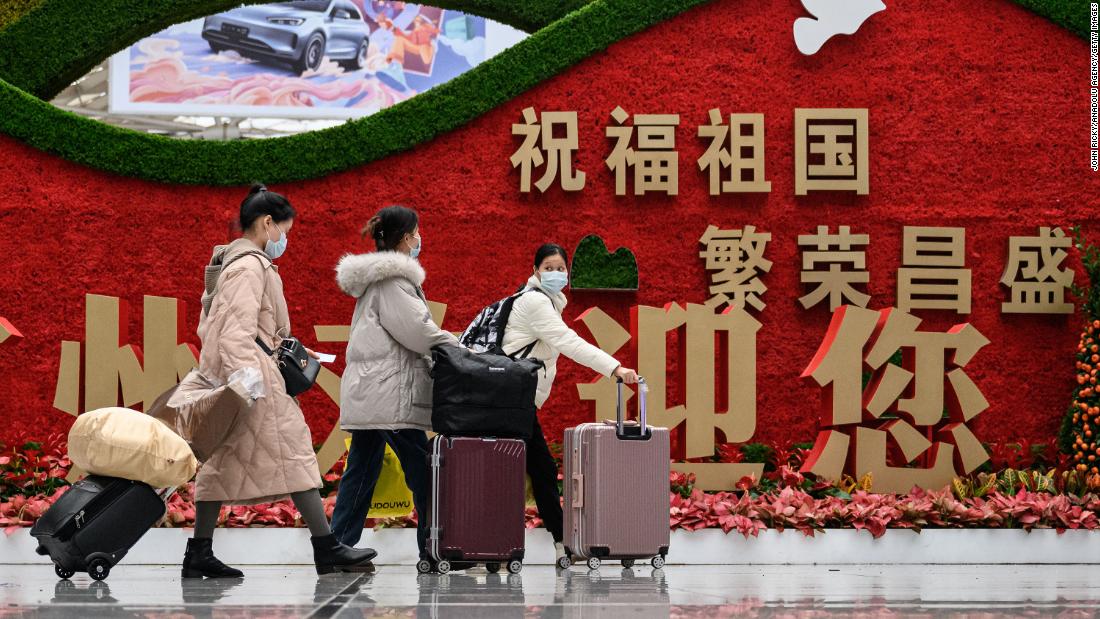 Passengers walk through a railway station in Guangzhou, China, on Thursday, January 12, as they prepare to travel to their hometowns for the Lunar New Year.