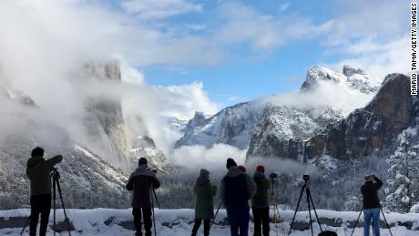 Photographers gather at a viewpoint overlooking Yosemite Valley as clouds begin to clear from the last of a series of atmospheric river storms to hit California on January 19.