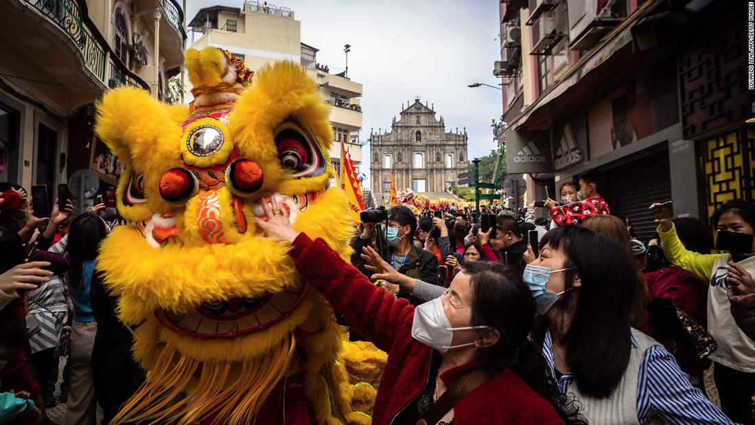 Women reach to touch a traditional Lion dance performer for good luck in front of the Ruins of St. Paul&#39;s during Lunar New Year celebrations in Macao on January 22.
