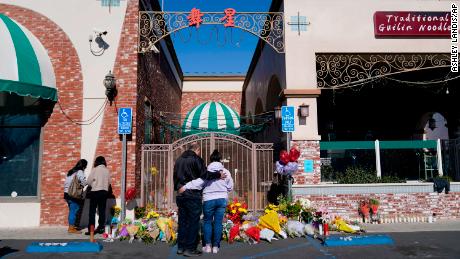 People stand near a memorial outside the Star Ballroom Dance Studio on January 24, 2023, in Monterey Park.