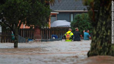Emergency workers and a man wade through flood waters in Auckland, New Zealand, on Jan. 27.
