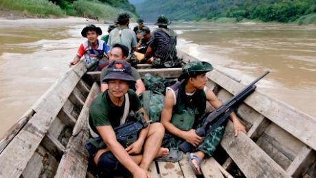 Members of a rebel group in Myanmar&#39;s eastern Karenni state on a boat, going from the Thai border into Myanmar.