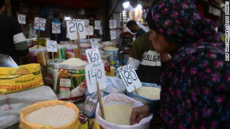 In this picture taken on January 10, 2023, a woman checks rice prices at a main wholesale market in Karachi. 