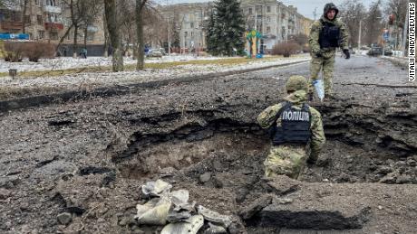 Police officers inspect a crater near the site of a damaged residential building on February 2 amid Russia&#39;s repeated attacks on Kramatorsk.