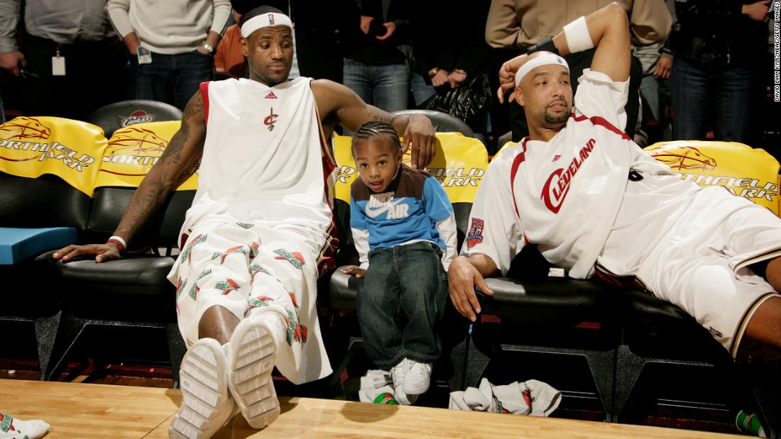 James sits with his young son, Bronny, and teammate Drew Gooden during a game in Cleveland in March 2007.