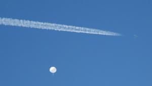 A jet flies by a suspected Chinese spy balloon as it floats off the coast in Surfside Beach, South Carolina, U.S. February 4, 2023.