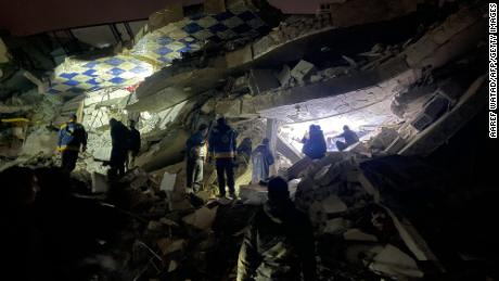 Syrian rescuers (White Helmets) and civilians search for victims and survivors amid the rubble of a collapsed building, in the rebel-held northern countryside of Syria&#39;s Idlib province on the border with Turkey, early on Monday.
