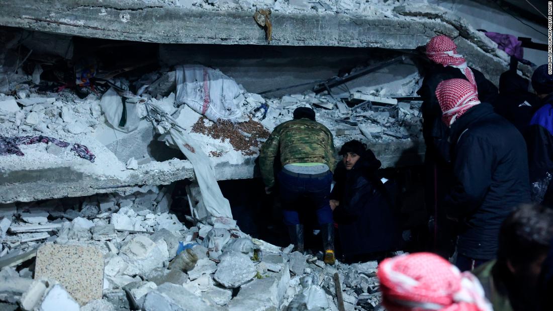 People search under the rubble of a building that collapsed in Azmarin, Syria.