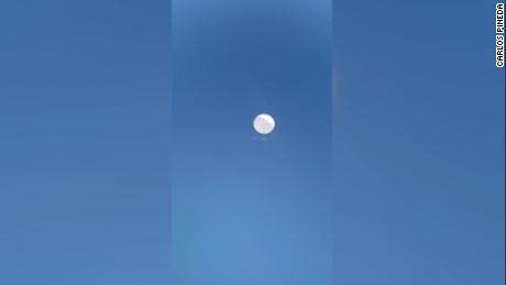 A screengrab taken from video shot by Carlos Pineda of a balloon flying over Valledupar, Colombia, at 1 p.m. on February 3. Pineda used a telescope and his cell phone to get the shot. A family member posted it on Twitter. CNN is unable to confirm if the images show a Chinese surveillance balloon. 