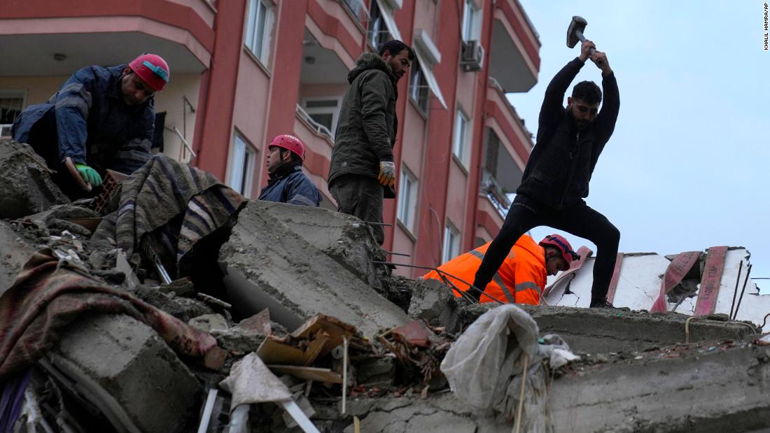 People search a destroyed building in Adana on February 6.