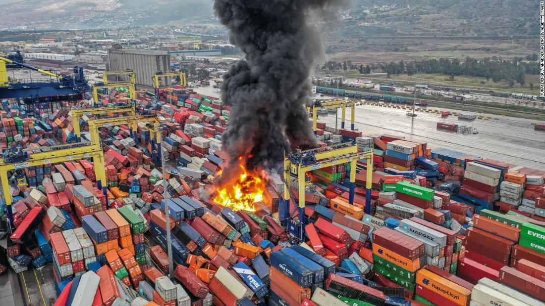 A fire burns near overturned containers in Hatay.