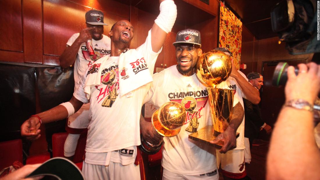 James celebrates with teammates after the Heat won the 2012 NBA Finals. James is holding the Larry O&#39;Brien Championship Trophy, right, and the Bill Russell Finals MVP Award. 