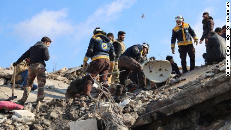 Syrian rescuers gather above the rubble of a collapsed building, on February 7, 2023, in the town of Jandaris, in the rebel-held part of Aleppo province, as a search operation continues following a deadly earthquake. - At least 1,444 people died across Syria after a devastating earthquake that had its epicentre in southwestern Turkey, the government and rescuers said. (Photo by Mohammed AL-RIFAI / AFP) (Photo by MOHAMMED AL-RIFAI/AFP via Getty Images)