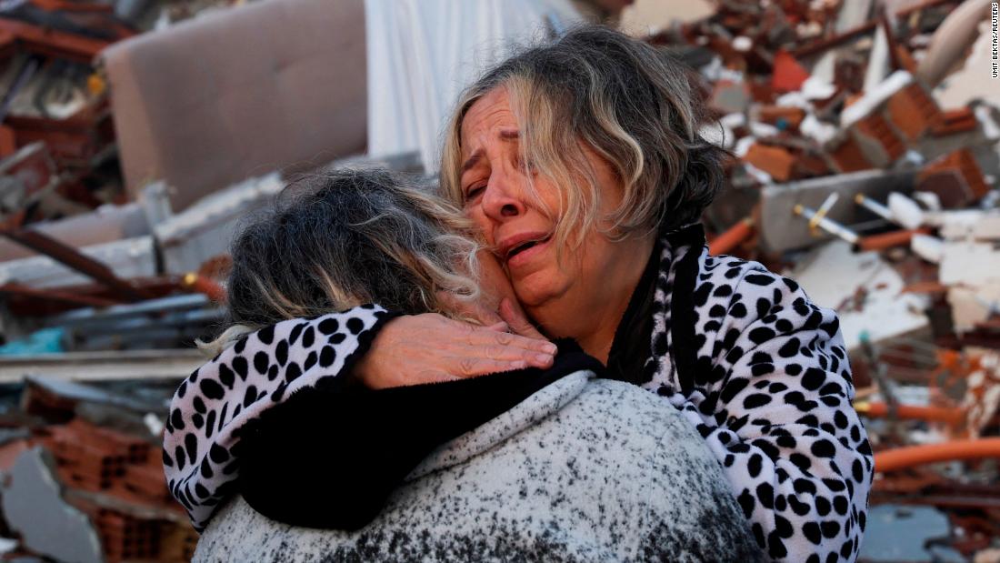 Two people embrace near the rubble of a collapsed building in Hatay on February 7.