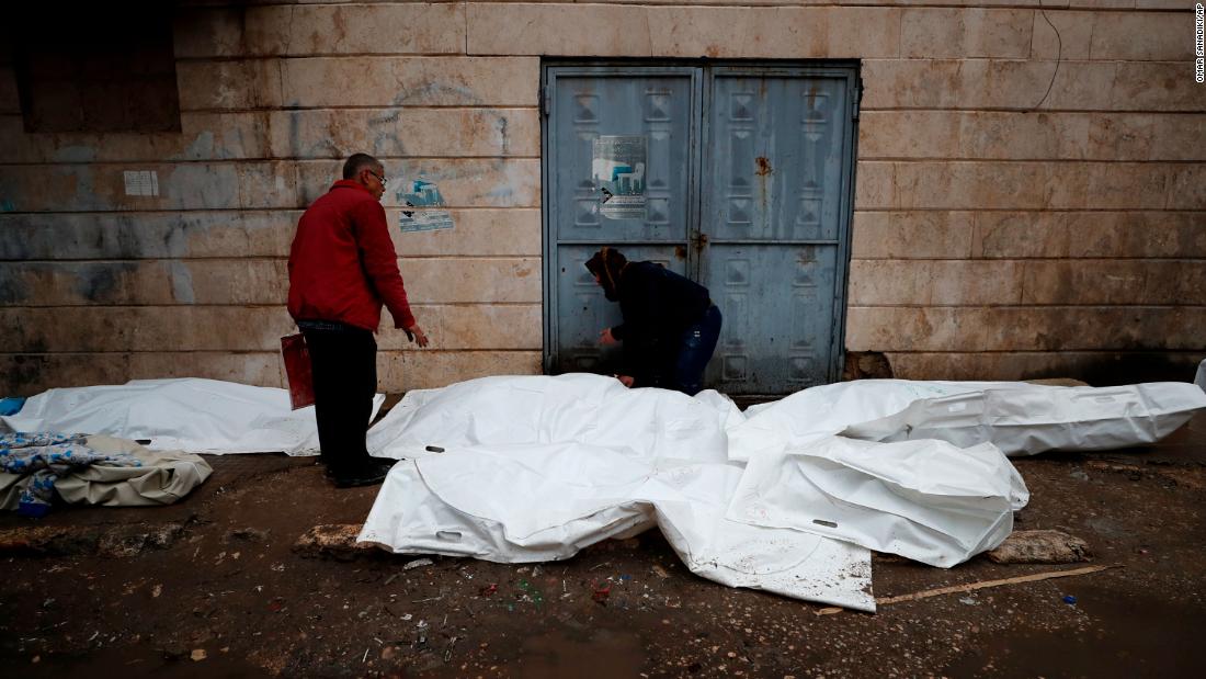 People try to identify the bodies of victims outside a hospital in Aleppo on February 6.