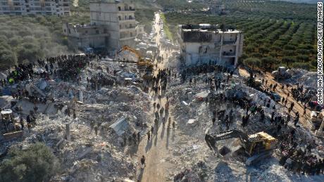 An aerial picture shows rescuers searching the rubble of buildings for casualties and survivors in the village of Besnaya in Syria&#39;s rebel-held northwestern Idlib province at the border with Turkey on Tuesday.
