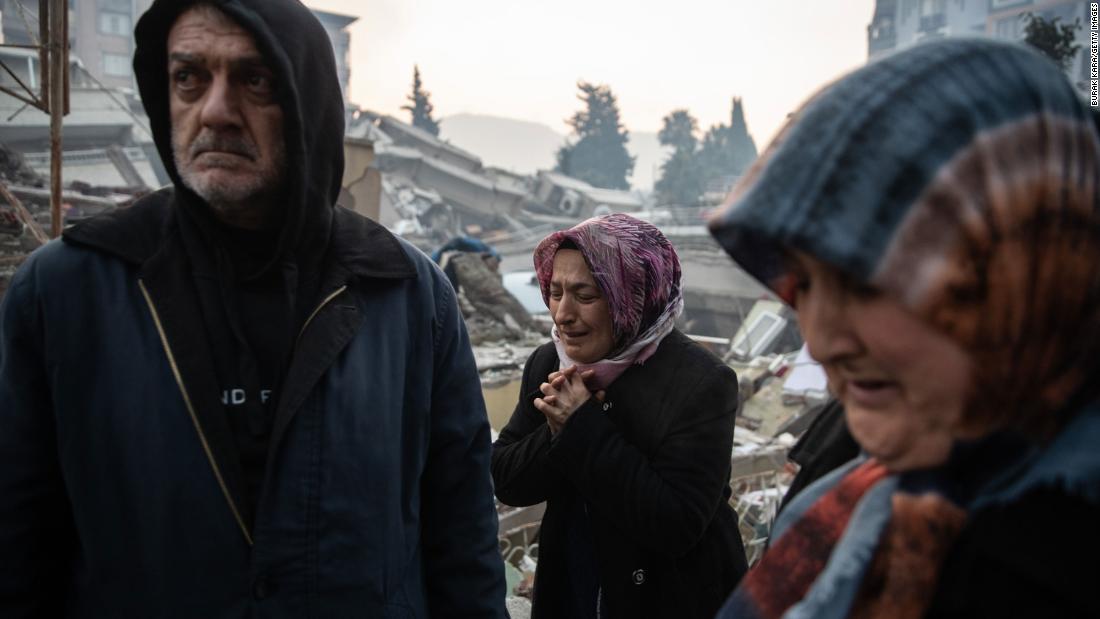 People wait for news of their loved ones, who were believed to be trapped under a collapsed building in Hatay on February 7.