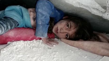 Video shows trapped child comfort sibling under rubble