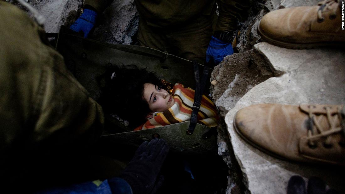 Rescuers move a 14-year-old girl from under some rubble in Kahramanmaras on February 9.