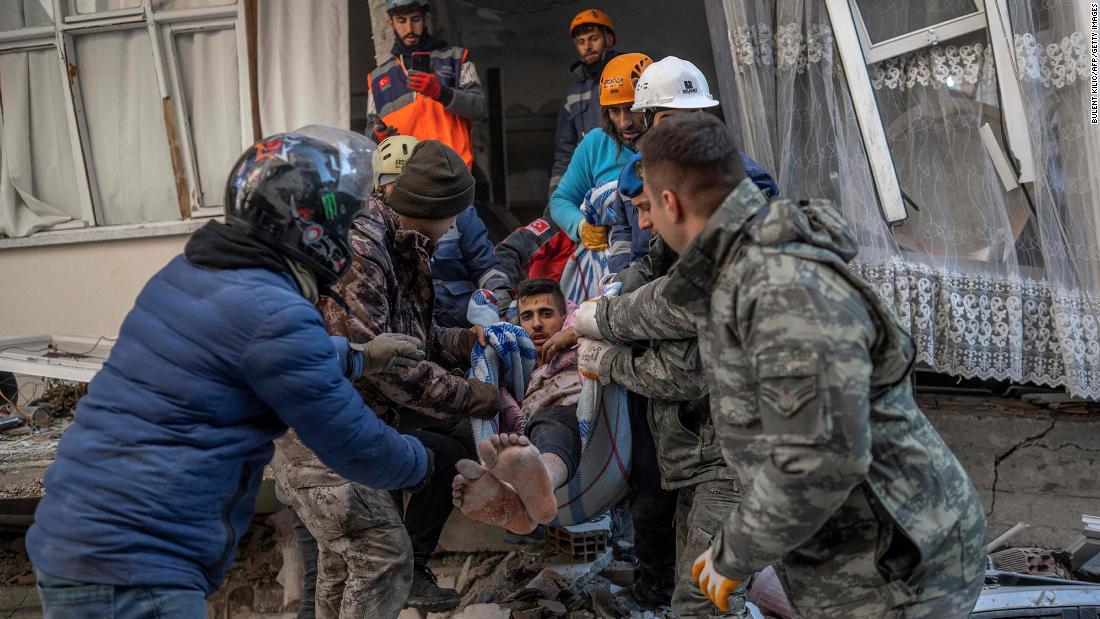 Rescuers carry a man who was stuck in the rubble for two days in Hatay.