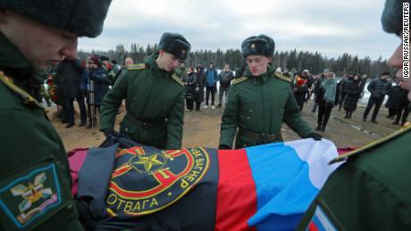 Military academy cadets cover the coffin with flags during the funeral of a Wagner Group mercenary killed in Ukraine at a cemetery in St. Petersburg, Russia, on December 24, 2022.